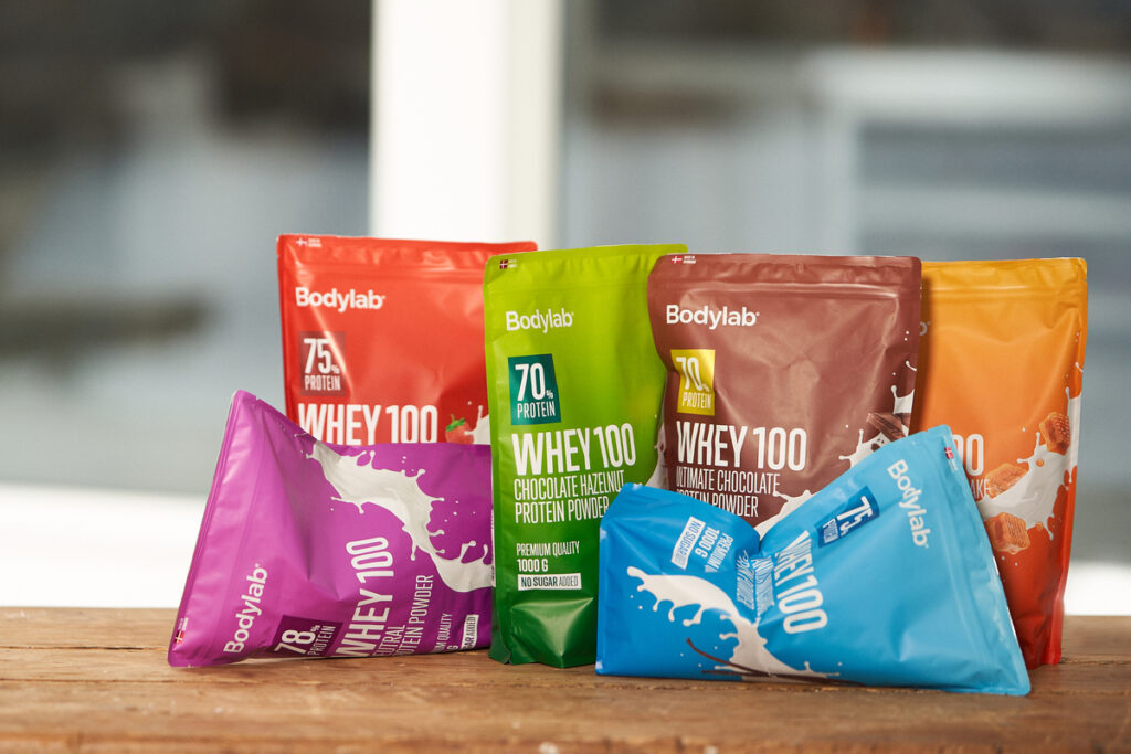 Proteiinijauheita eri maku- ja pakkausväreissä esillä pöydällä