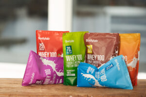 Proteiinijauheita eri maku- ja pakkausväreissä esillä pöydällä