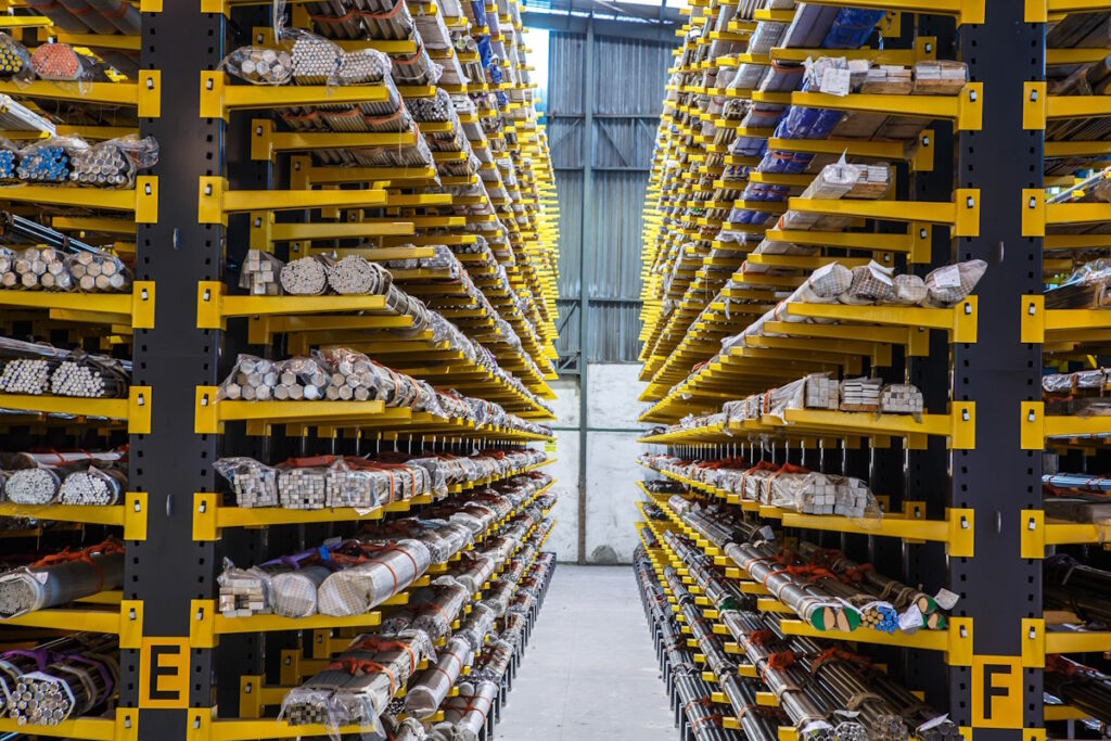Keltaiset ulokehyllyt, joissa säilytetään pitkiä metallitankoja, putkia ja profiileja teollisuusvarastossa
